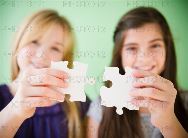 Close up of hands of girls holding jigsaw puzzles. Photo : Jamie Grill