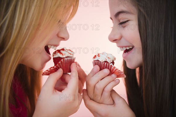 Close up of two girls eating cupcakes. Photo : Jamie Grill
