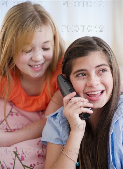 Close up of two girls talking on phone. Photo : Jamie Grill