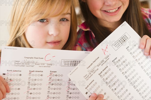 Close up of two girls showing test results. Photo : Jamie Grill