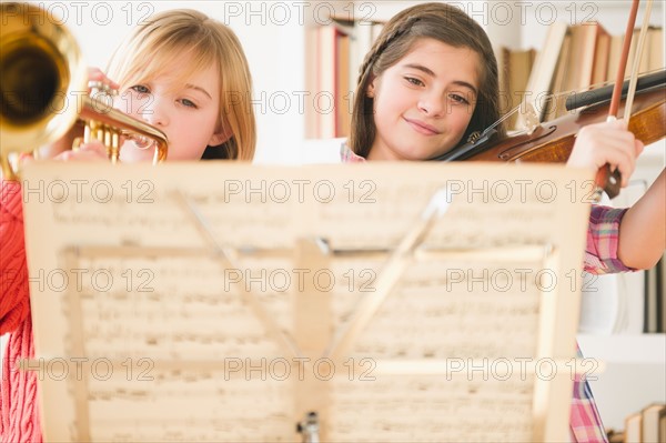Two girls playing instruments from sheet music. Photo : Jamie Grill