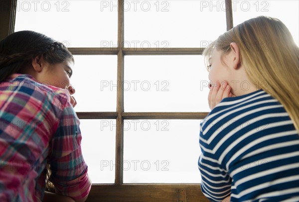 Two girls sitting by window. Photo : Jamie Grill