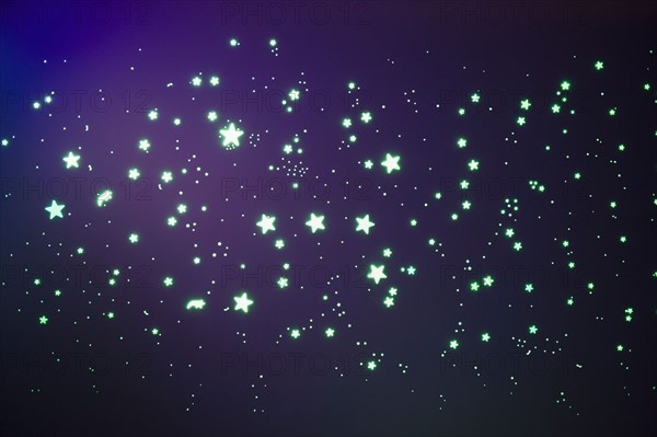 Fluorescent stars on blue background, studio shot. Photo : Jamie Grill