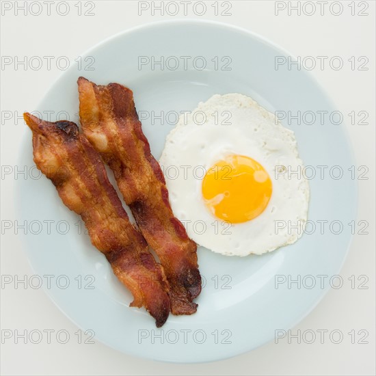Close up of fried egg with bacon, studio shot. Photo : Jamie Grill