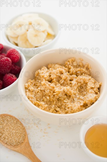 Close up of oats and fruits in bowls, studio shot. Photo : Jamie Grill