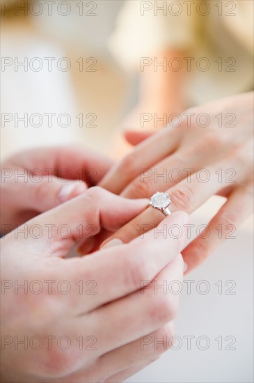 Close up of man's and woman's hands with engagement ring. Photo : Jamie Grill