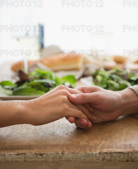 Close up of couple's hands on table. Photo : Jamie Grill