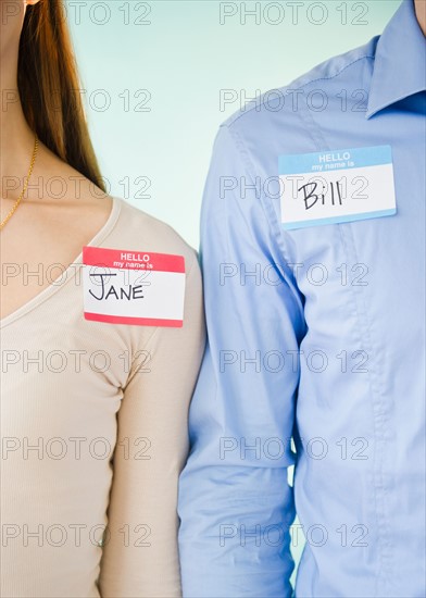 Close up of man and woman standing arm in arm, studio shot. Photo : Jamie Grill