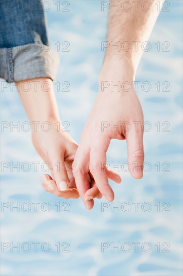 Close up of hands of couple, studio shot. Photo : Jamie Grill