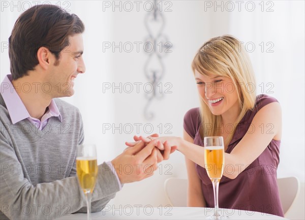 Couple celebrating engagement in restaurant. Photo : Daniel Grill