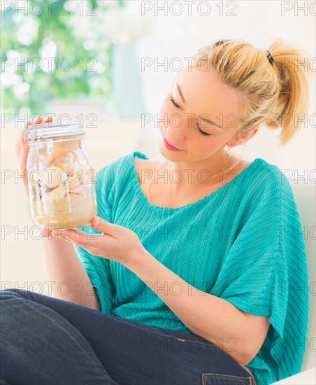 Young woman holding shells in jar. Photo : Daniel Grill