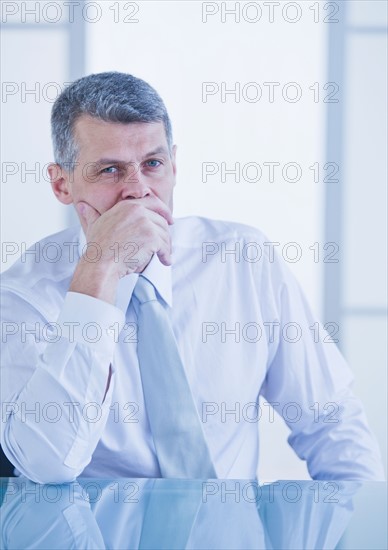 Portrait of businessman sitting at desk. Photo : Daniel Grill