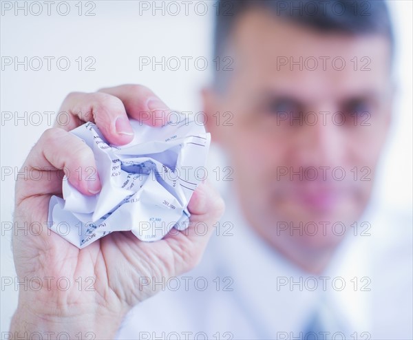 Man holding crumpled paper ball. Photo : Daniel Grill