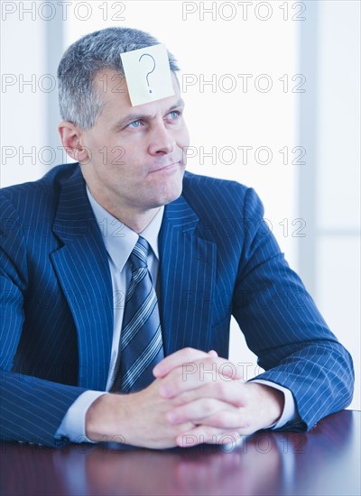 Portrait of businessman with label on forehead. Photo : Daniel Grill