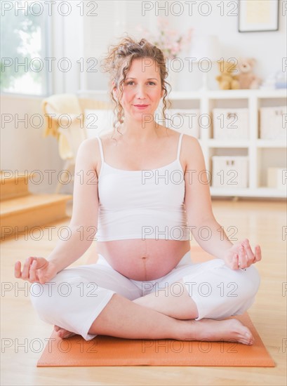 Pregnant woman practicing yoga. Photo : Daniel Grill