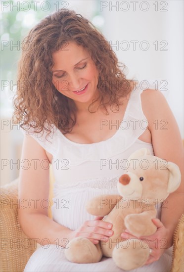 Portrait of pregnant woman with teddy bear. Photo : Daniel Grill