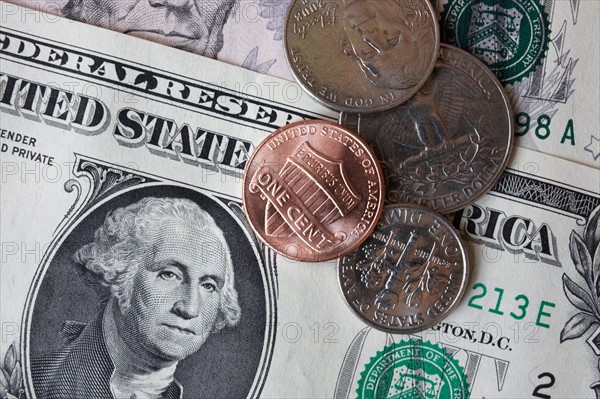 Close-up of dollar banknotes and coins. Photo : Winslow Productions