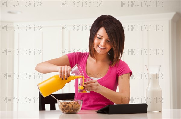 Young woman preparing breakfast. Photo : Mike Kemp