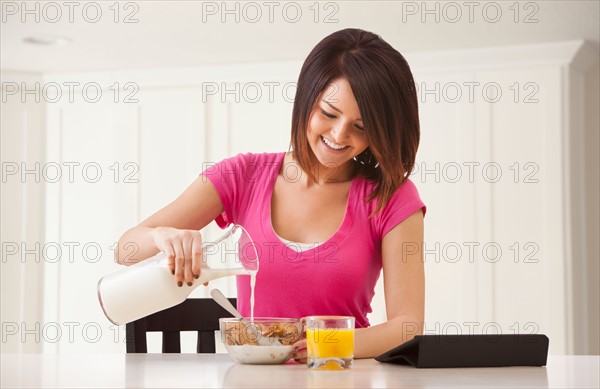 Young woman preparing breakfast. Photo : Mike Kemp