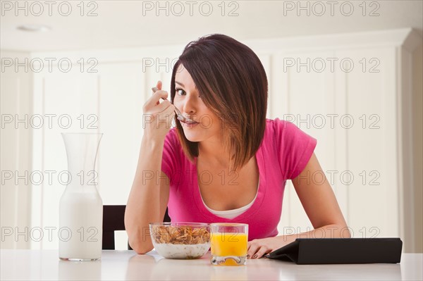 Young woman preparing breakfast. Photo : Mike Kemp