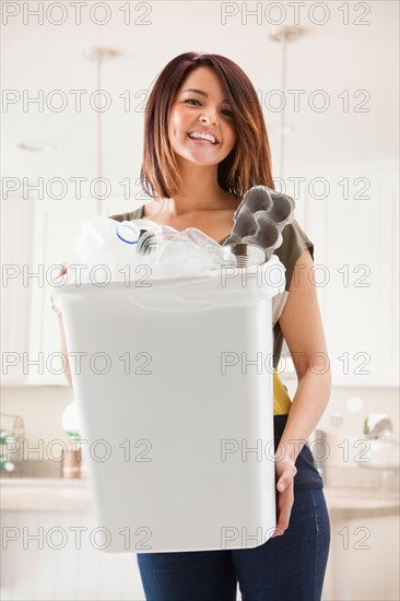 Portrait of young woman with waste bin. Photo : Mike Kemp