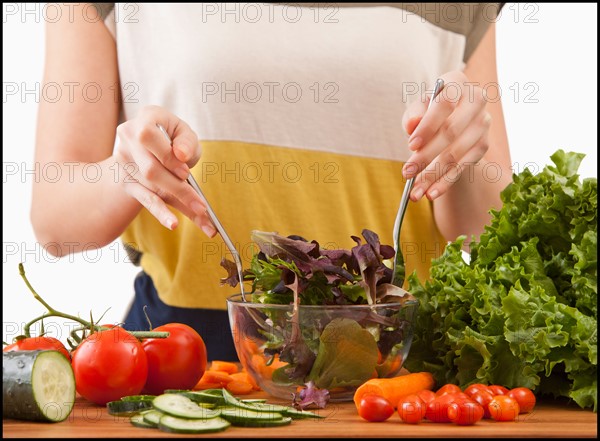 Young woman preparing salad. Photo : Mike Kemp