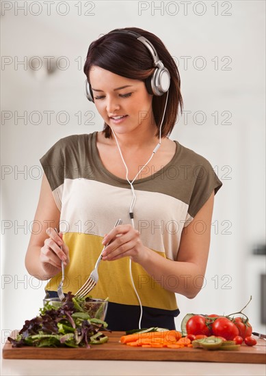 Young woman preparing salad. Photo : Mike Kemp