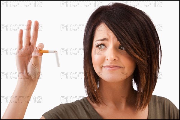 Young woman breaking cigarette. Photo : Mike Kemp