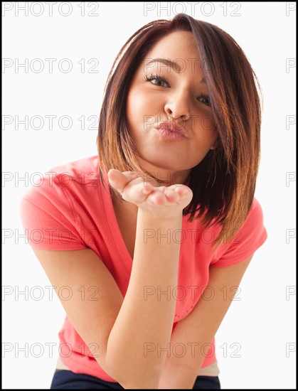 Portrait of young happy woman blowing kiss. Photo : Mike Kemp