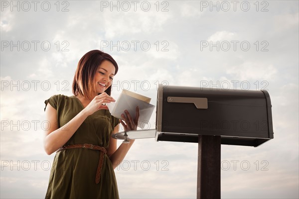 Young woman at mailbox. Photo : Mike Kemp