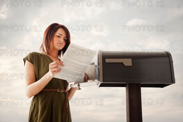 Young woman at mailbox. Photo : Mike Kemp