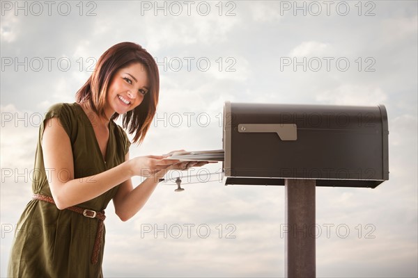 Young woman at mailbox. Photo : Mike Kemp