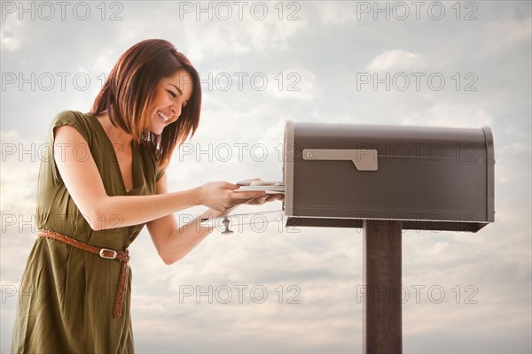 Young woman at mailbox. Photo : Mike Kemp