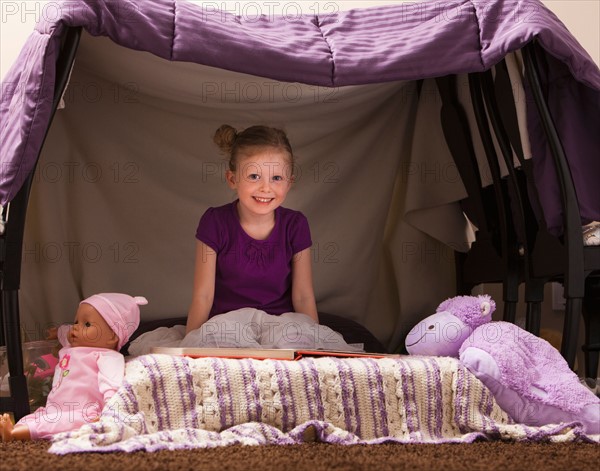 Portrait of happy girl (4-5) in playhouse. Photo : Mike Kemp