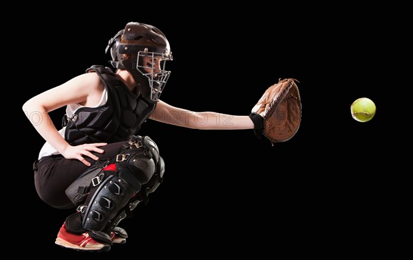 Girl (12-13) plying softball, studio shot. Photo : Mike Kemp