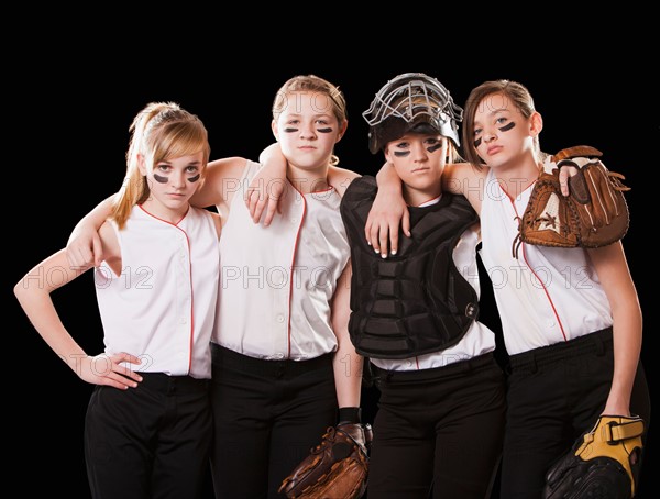 Portrait of girls (12-13) playing softball. Photo : Mike Kemp