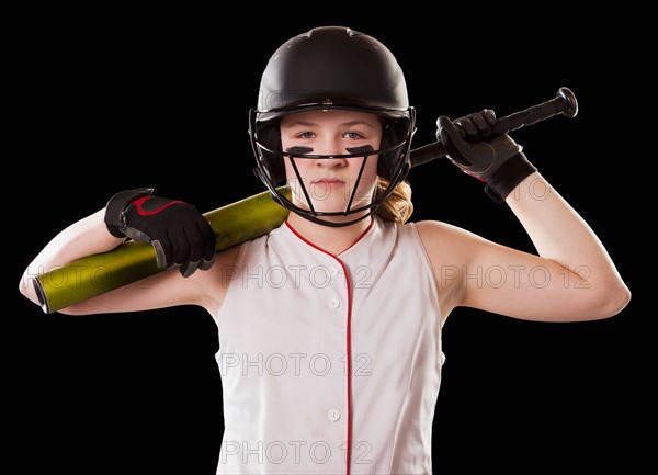 Portrait of girl (12-13) plying softball, studio shot. Photo : Mike Kemp