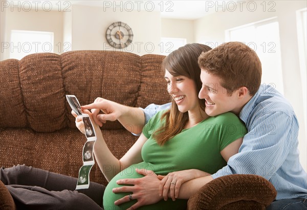 Pregnant woman with boyfriend watching ultrasonography scan. Photo : Mike Kemp