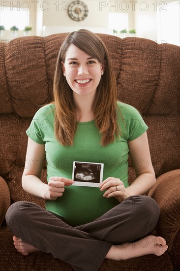 Portrait of pregnant woman showing ultrasonography scan. Photo : Mike Kemp