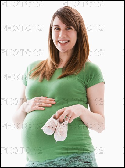 Studio Shot of woman holing baby booties. Photo : Mike Kemp