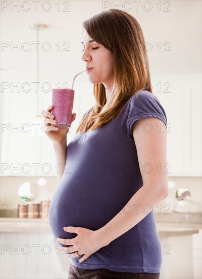 Young woman drinking smoothie. Photo : Mike Kemp