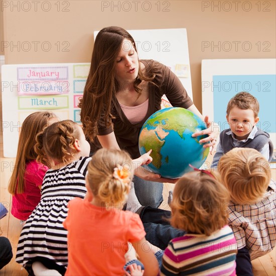 Teacher with children (2-3, 4-5) learning geography. Photo : Mike Kemp