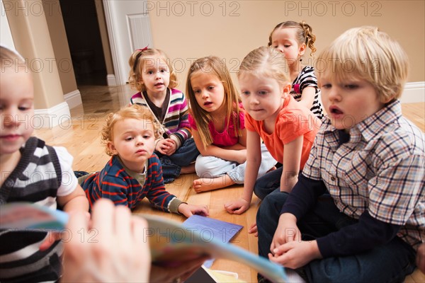 Children (2-3, 4-5) sitting on floor and learning. Photo : Mike Kemp