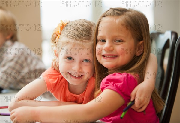 Portrait of girls (4-5)  looking at camera in kindergarten. Photo : Mike Kemp