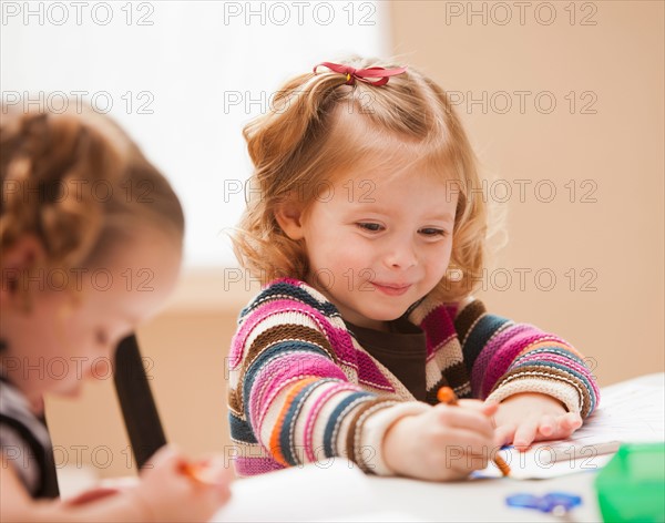 Girl (4-5) drawing in kindergarten. Photo : Mike Kemp