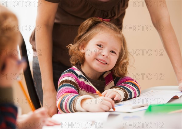 Girl (4-5) drawing in kindergarten. Photo : Mike Kemp