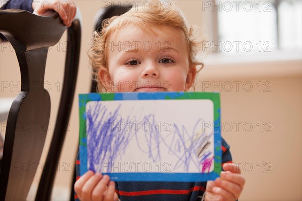 Boy (4-5) showing his drawing. Photo : Mike Kemp