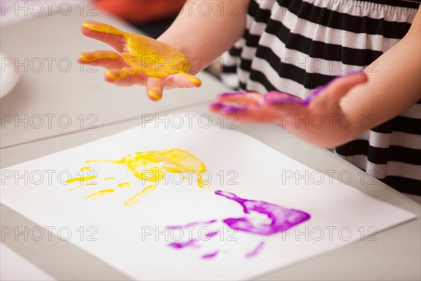 Girl's (4-5) hands printed on paper. Photo : Mike Kemp