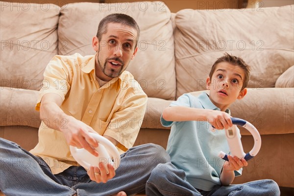 Front view of father and son (8-9) playing Video Games. Photo : Mike Kemp