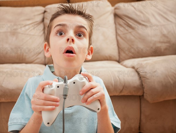 Front view of boy (8-9) playing Video Games. Photo : Mike Kemp